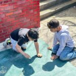 two boys drawing with chalk
